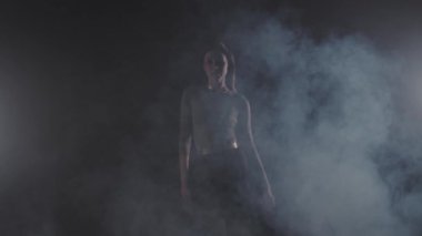 Vogue - genç bir kadın bir mankene biner karanlık odada yürür ve dans etmeye başlar