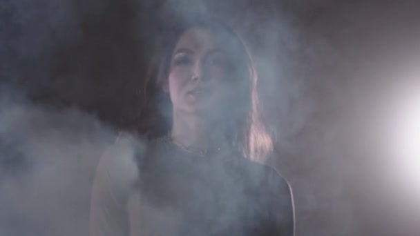 Ung sexig kvinna går i mörk rökig studio — Stockvideo