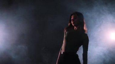 Vogue dumanla dolu stüdyoda dans ediyor. Seksi dans eden çekici bir kadın.