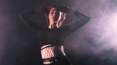 Vogue dumanla dolu stüdyoda dans ediyor. Çekici bir kadın içeri giriyor ve dansına başlıyor.