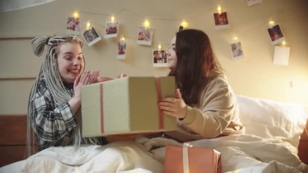 Młode lesbijki leżące w łóżku - dając prezent i przytulanie — Wideo stockowe
