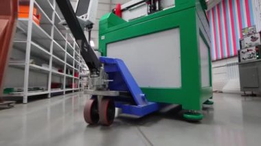 Adamın biri sanayi deposundan bir yük arabasıyla geçiyor.