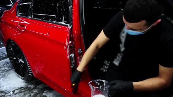 Az ember mossa nehezen elérhető helyeken autó ajtók ecsettel — Stock videók