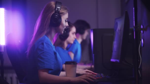 Gruppe af venner sidder i gaming klub og har en online gaming turnering kvinde drikker kaffe på forgrunden – Stock-video