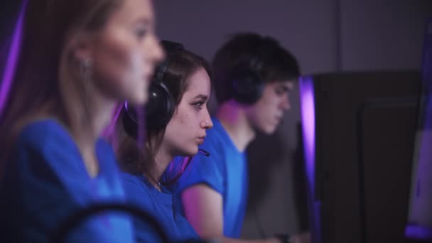 Groupe d'un homme et deux femmes assis dans le club de jeu et ayant un tournoi de jeu en ligne — Video