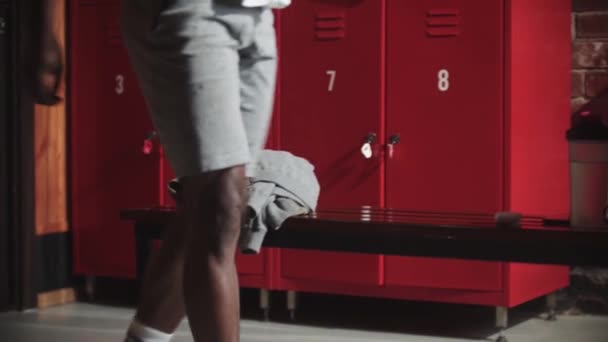 Afroamerikanischer junger Mann trinkt Wasser in der Umkleidekabine — Stockvideo