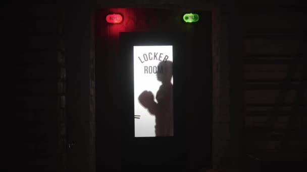 Bokser w rękawiczkach bokserskich stojący za drzwiami do szatni — Wideo stockowe