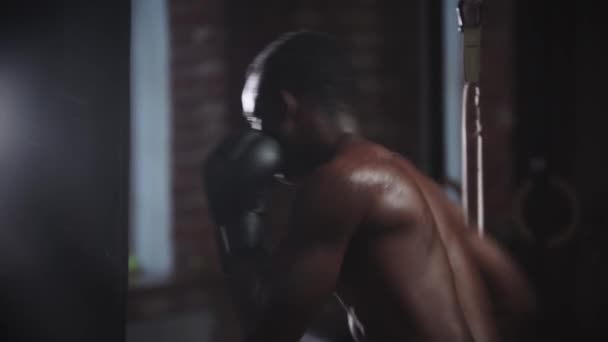 Preto jovem boxer treinamento soco no saco de perfuração no ginásio — Vídeo de Stock