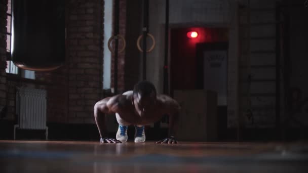 Un hombre guapo negro entrenando en el gimnasio haciendo flexiones — Vídeo de stock