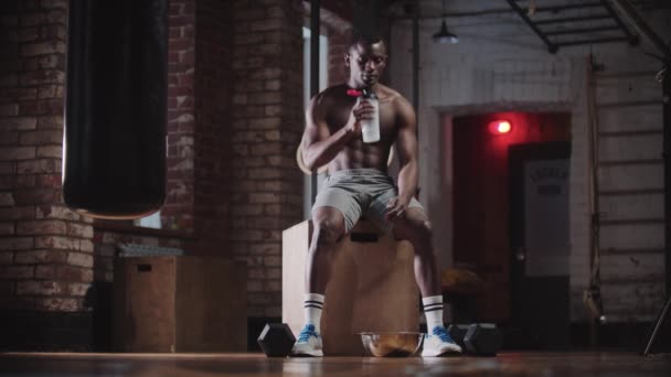 Egy fekete jóképű férfi edz az edzőteremben - ivóvíz — Stock videók