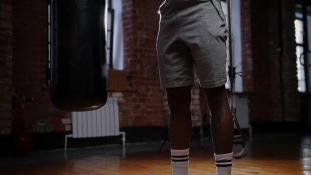 Um homem afro-americano a bombear os músculos das mãos com dois halteres no ginásio — Vídeo de Stock
