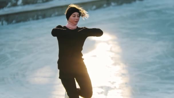 Patinaje sobre hielo en la mañana temprano - joven hermosa mujer patinaje artístico — Vídeo de stock