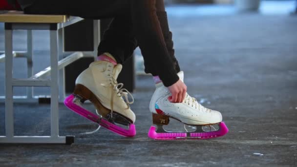 Mujer ata cordones de zapatos en patines blancos en vestuario — Vídeos de Stock
