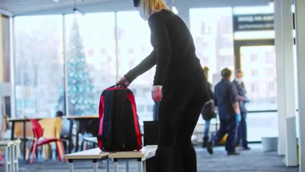 Schlittschuhlaufen - junge Frau zieht in öffentlicher Umkleidekabine ihre Schlittschuhe aus — Stockvideo