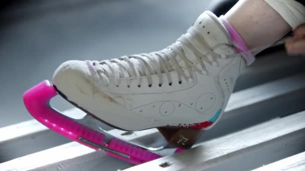 Patinaje sobre hielo - mujer joven ata cordones en patines blancos — Vídeos de Stock