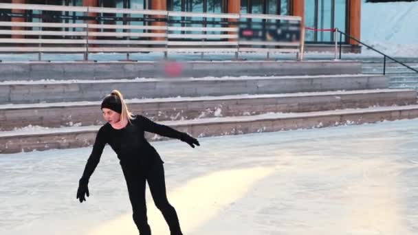 Fiatal nő korcsolyázás nyilvános jégpályán — Stock videók