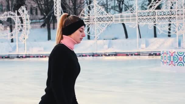 年轻女子慢慢地在公共冰场上滑冰 — 图库视频影像