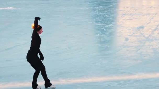 युवा महिला सार्वजनिक बर्फ रिंक आउटडोर पर अपनी आंकड़ा स्केटिंग प्रशिक्षण — स्टॉक वीडियो