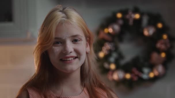 Kerstconcept - een lachend meisje mooi blond meisje met haar gezicht bedekt met bloem — Stockvideo