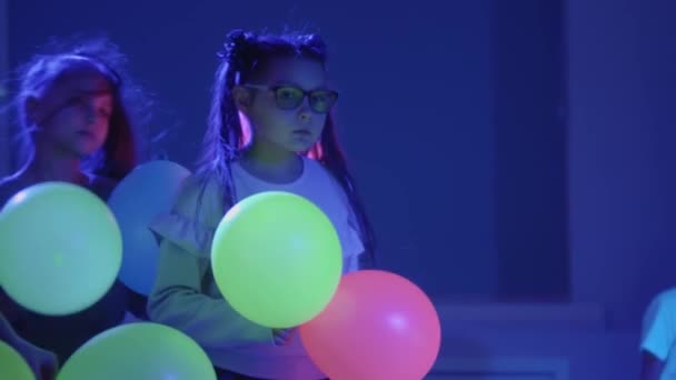 Kinder halten Luftballons im Neon-Raum — Stockvideo