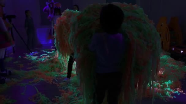 Verjaardagsfeest - kleine kinderen spelen met kleurrijke linten in neon verlichting — Stockvideo
