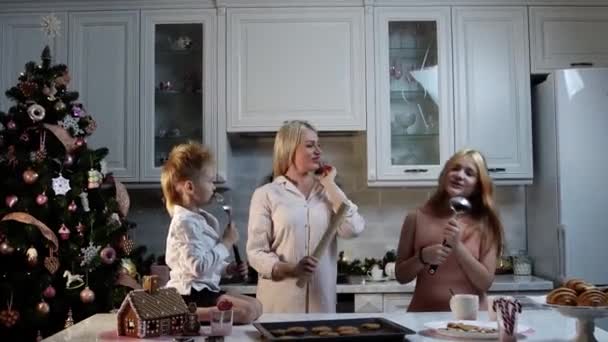 Rodzinne święta - mama i jej dzieci gotują ciasteczka - córka śpiewa w łyżce — Wideo stockowe