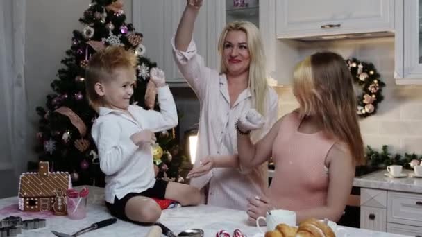 Noël en famille - maman et ses enfants cuisinent des biscuits - jouer avec la farine — Video