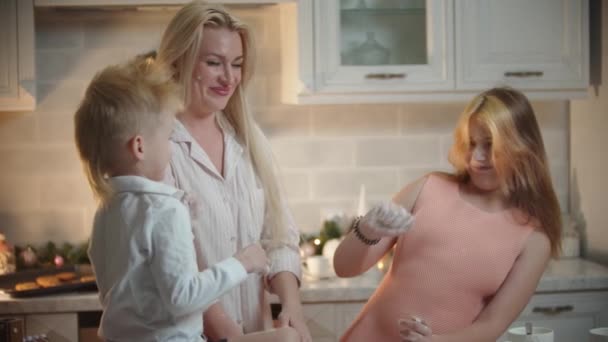 Noël en famille - maman et ses enfants s'amusent dans la cuisine - jouer avec la farine — Video