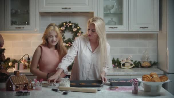 Rodzinne święta - mama i jej córka robią ciasteczka - wylewają mąkę na wierzch ciasteczek — Wideo stockowe