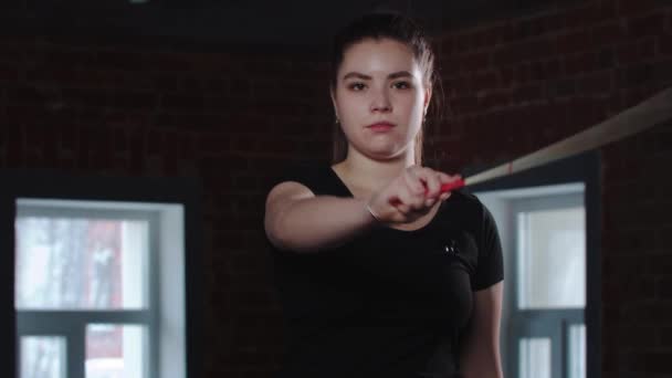 Jonge vrouw gymnast spelen met een kleurrijk lint in de studio — Stockvideo