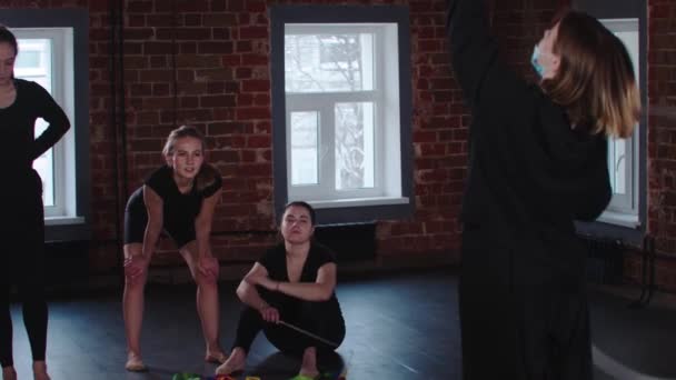 Les jeunes femmes gymnastes en formation en studio - l'entraîneur jouant avec un cerceau — Video