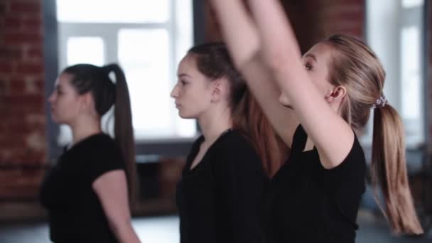 Fitness - drei junge Frauen sitzen auf dem Boden und strecken sich nacheinander um die Zehenspitzen — Stockvideo