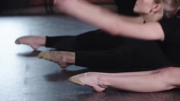 건강 - 유연 한 세 명의 젊은 여성이 바닥에 앉아 발가락을 하나씩 앞으로 뻗어 있다 — 비디오