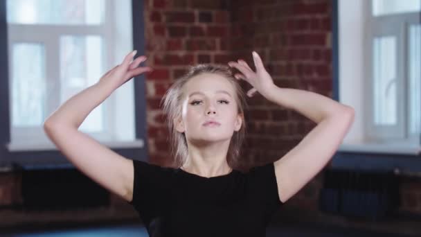 Gymnastik - blond ung kvinna som sitter i en horisontell split och lutar sig framåt - tittar i en kamera — Stockvideo