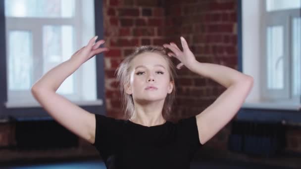 Gymnastics - blonde young woman sitting in a horizontal split and leaning forwards - looking in a camera — Video