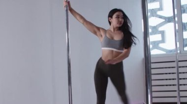 Direk dansı - kadın antrenör ve öğrencileri direğin kenarında dans ediyorlar - temel dönüşleri yapıyorlar