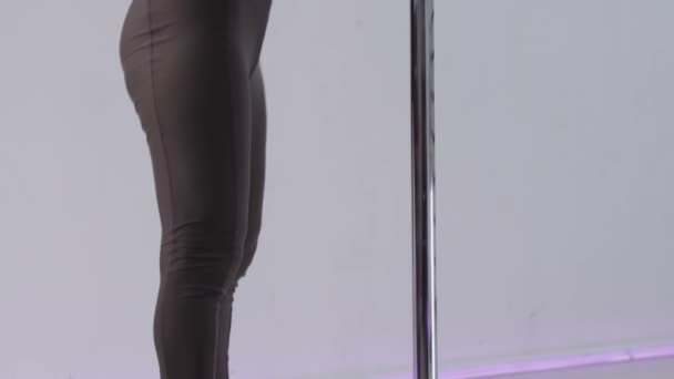 Pole dancing - una donna che mostra un movimento di danza di base vicino al palo — Video Stock