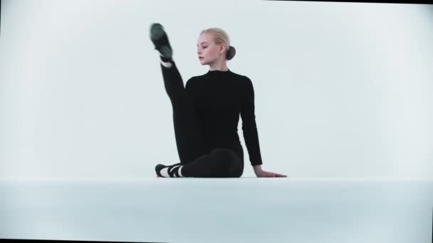 Gymnastique - jeune femme assise dans une fente et regardant dans la caméra — Video