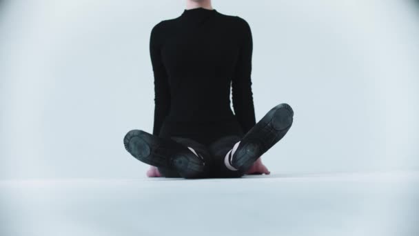 Спортивная гимнастика - молодая женщина, сидящая на полу и наклоняющаяся вперед к ногам — стоковое видео