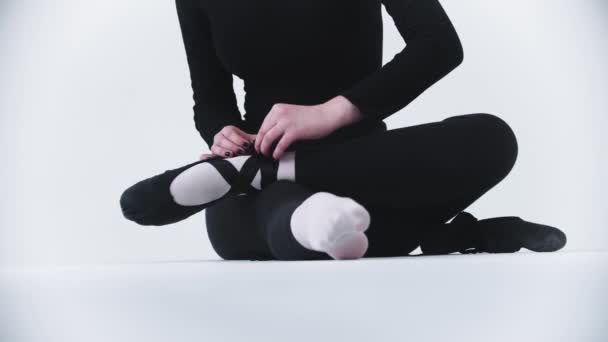 Jonge vrouw ballerina doet haar puntschoenen uit — Stockvideo