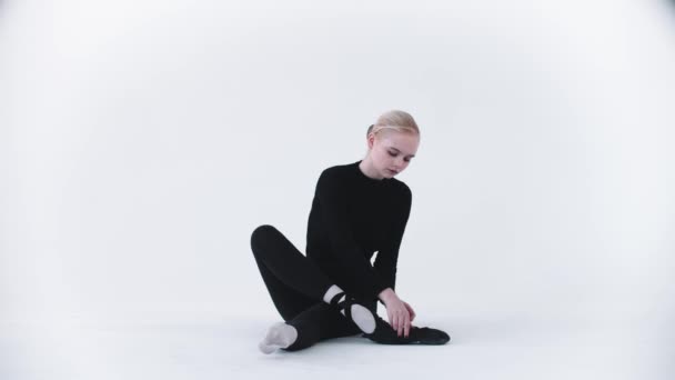 Joven bailarina rubia poniéndose sus zapatos puntiagudos — Vídeos de Stock