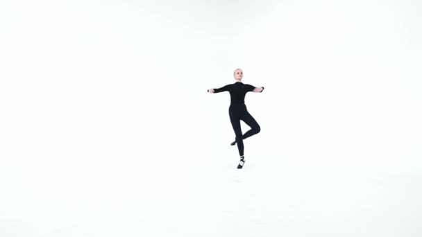 Giovane ballerina che esegue piroette su sfondo bianco — Video Stock