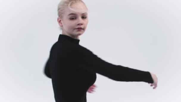 Спортивная гимнастика - молодая блондинка крутится в студии и смотрит в камеру — стоковое видео