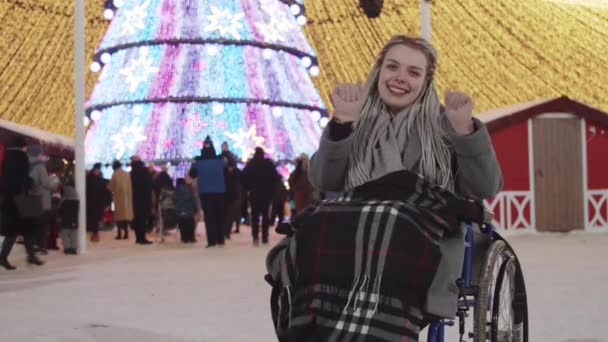 Mujer joven en silla de ruedas en la fiesta de Navidad en las calles - bailando y divirtiéndose — Vídeos de Stock