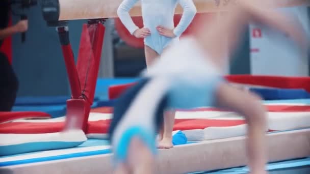 Гимнастические дети, занимающиеся на спортивной арене — стоковое видео