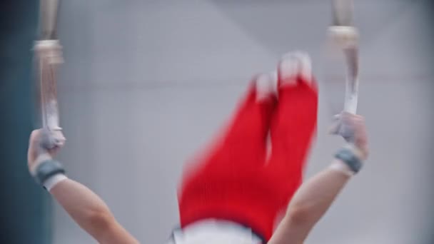 Маленький мальчик делает гимнастические упражнения на кольцах — стоковое видео