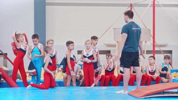 RUSSIE, KAZAN 27-12-20 : Des petits garçons assis sur les nattes et leur entraîneur debout devant eux - gymnastique — Video