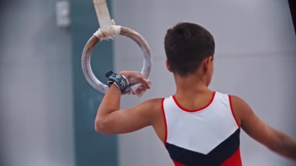 RUSSIA, KAZAN 27-12-20: mały gimnastyk wiszący na ringu sportowym — Wideo stockowe