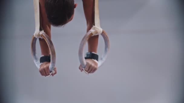 RUSSIA, KAZAN 27-12-20: mały gimnastyk stojący do góry nogami za pomocą pierścieni sportowych i ćwiczący — Wideo stockowe