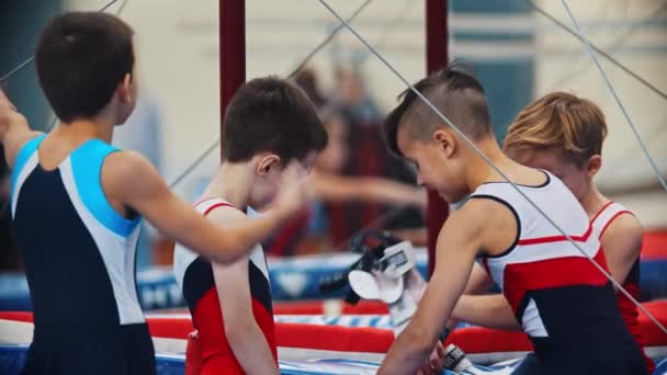 РОССИЯ, КАЗАН 27-12-20: группа мальчиков-гимнасток на спортивной арене - один из мальчиков надевает медицинскую маску в рюкзак — стоковое видео